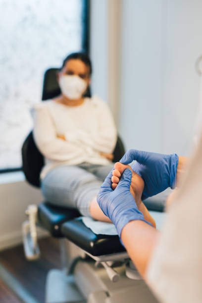 Home chiropodist doing pedicure to patient in medical center